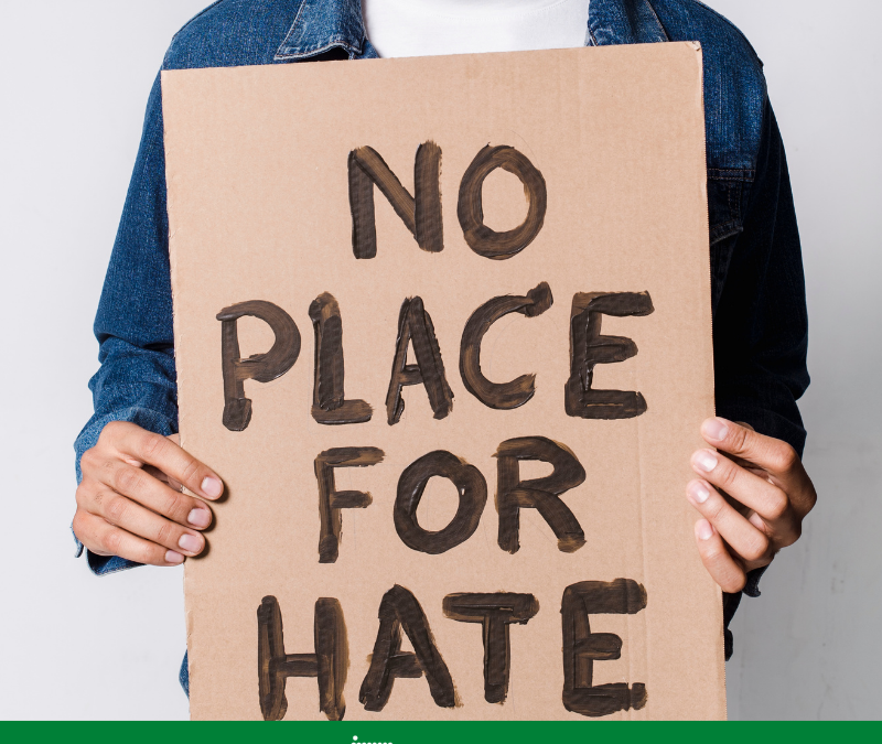 Person hält ein Schild: No pLace for Hate