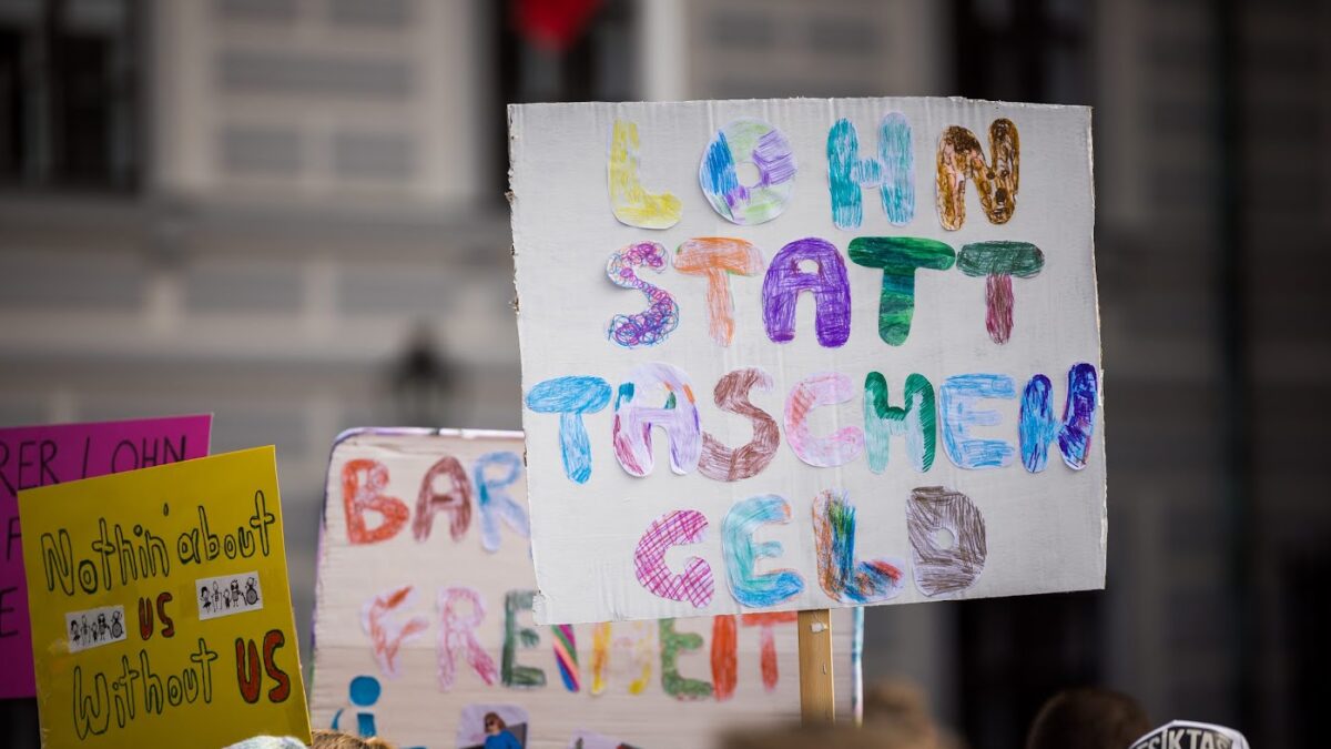 Inklusions-Demo am Wiener Ballhausplatz, 28. September 2022. Auf dem Bild sind Plakate zu sehen. Auf einem steht "Lohn statt Taschengeld".