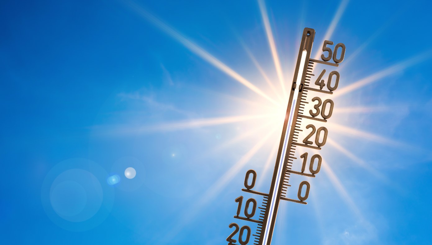Bild eines Thermometers mit der Sonne im Hintergrund