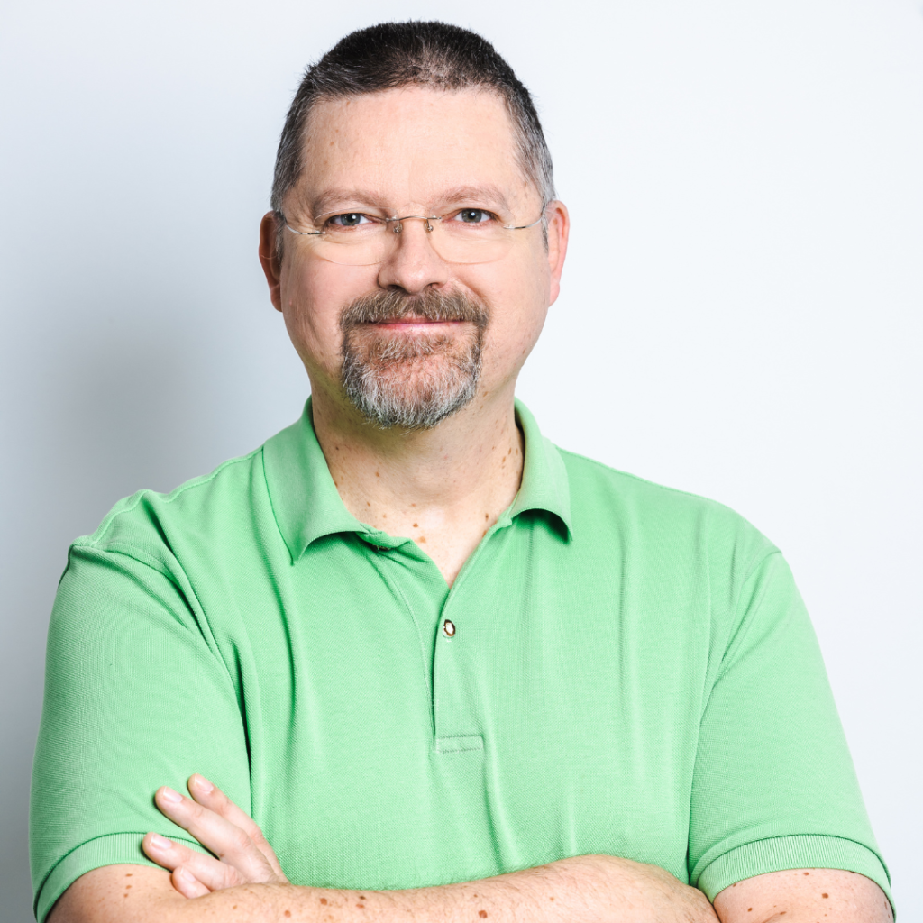 Portrait Friedrich Rücker, er hat braunes, kurzes Haar, trägt eine Brille und ein hellgrünes Poloshirt