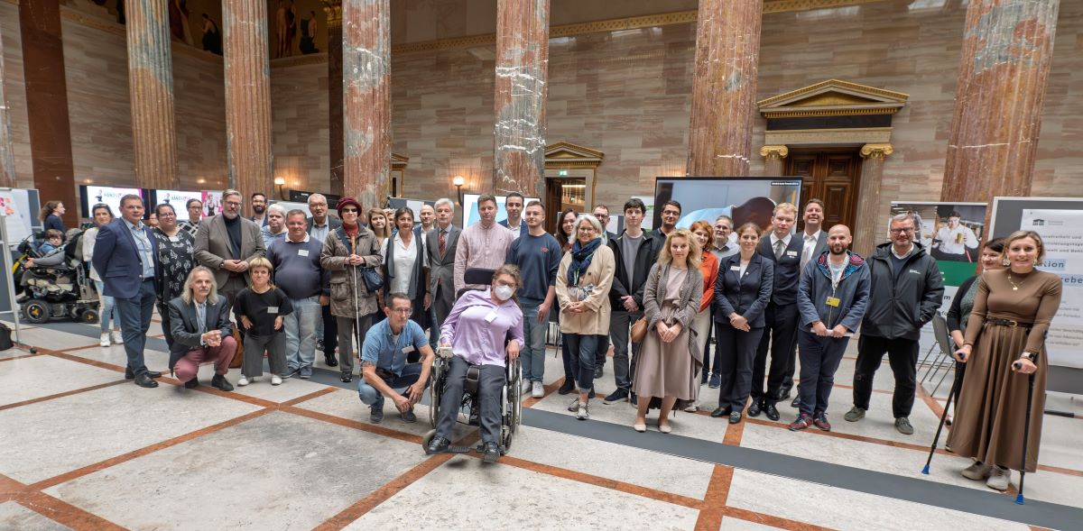 Gruppenfoto von etwa 30 Personen in der Säulenhalle des Parlaments