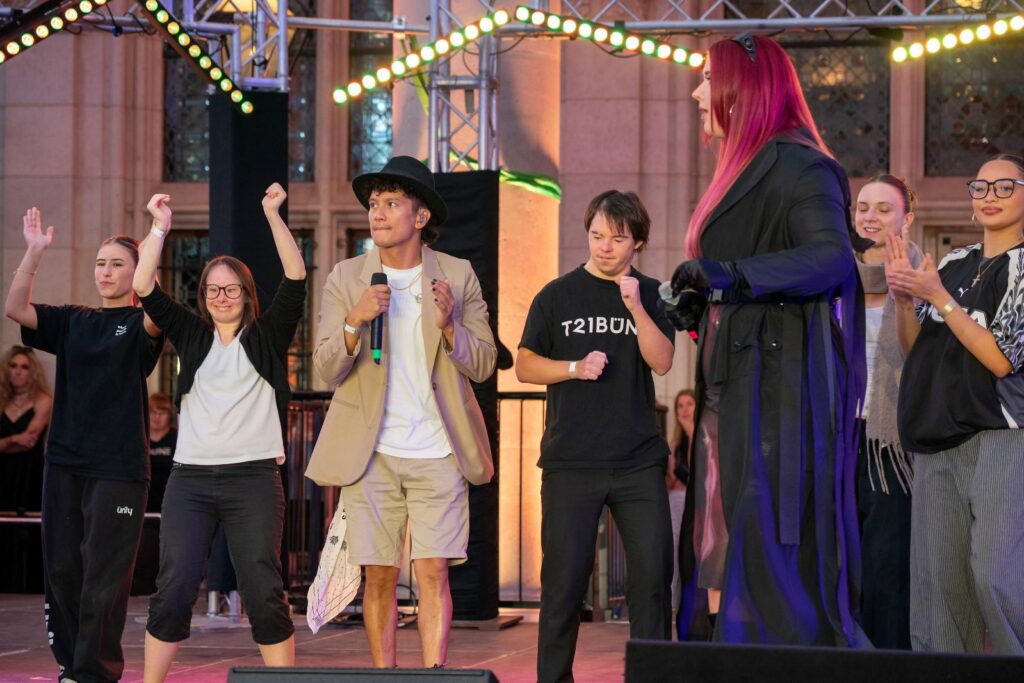 7 Personen singen und tanzen auf einer Bühne