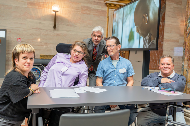 an einem Tisch sitzende Personen in der Säulenhalle des Parlaments