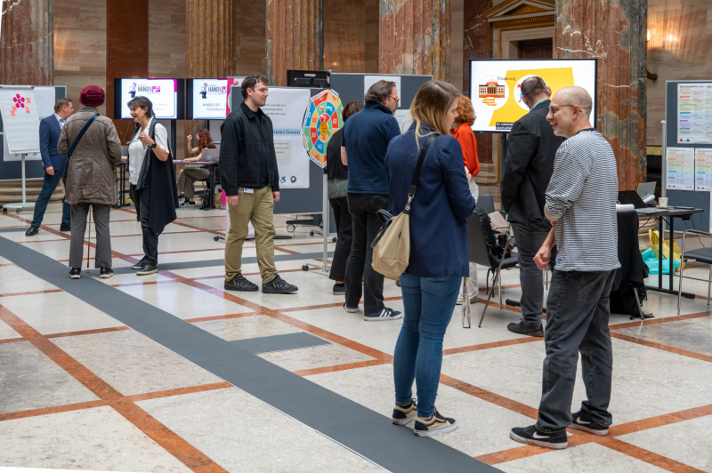 Stehende Personen unterhalten sich in der Säulenhalle des Parlaments