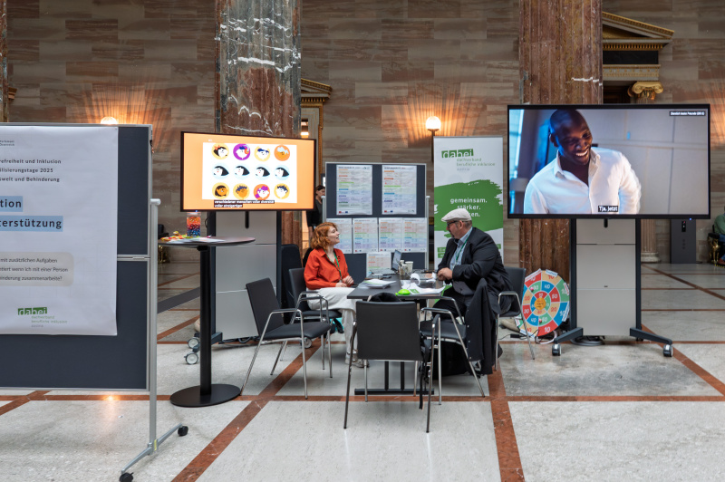 an einem Tisch sitzende Personen in der Säulenhalle des Parlaments