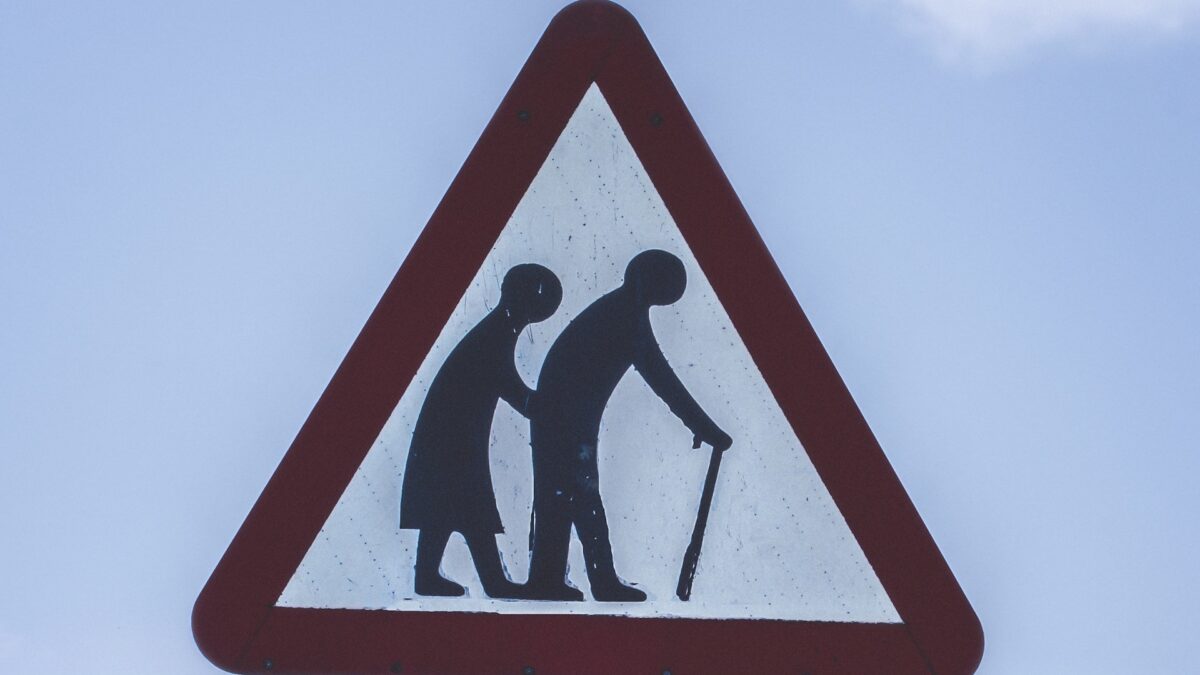 Straßenschild mit Piktogramm eines alten Paares, auf einen Gehstock gestützt