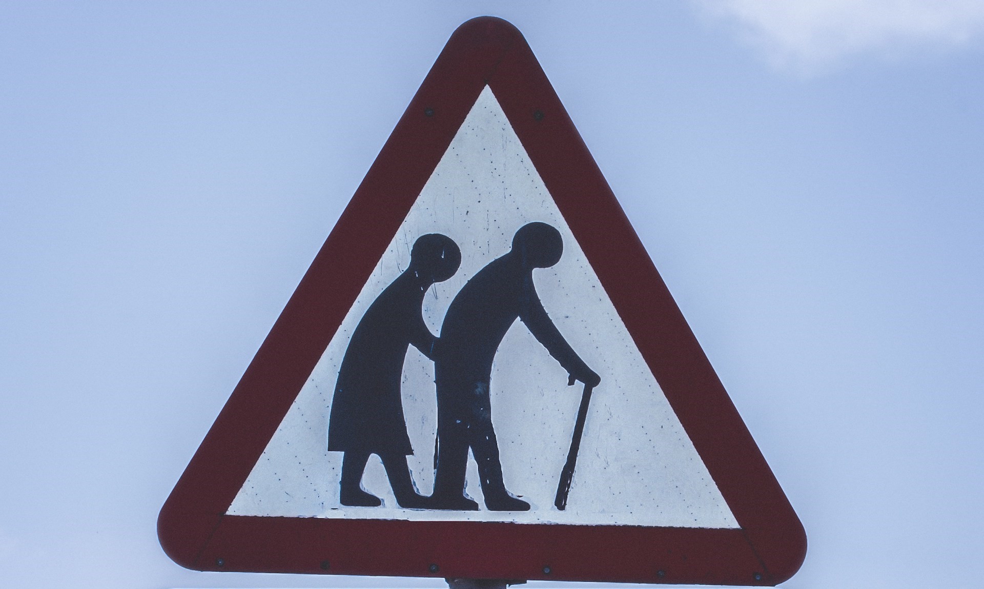 Straßenschild mit Piktogramm eines alten Paares, auf einen Gehstock gestützt