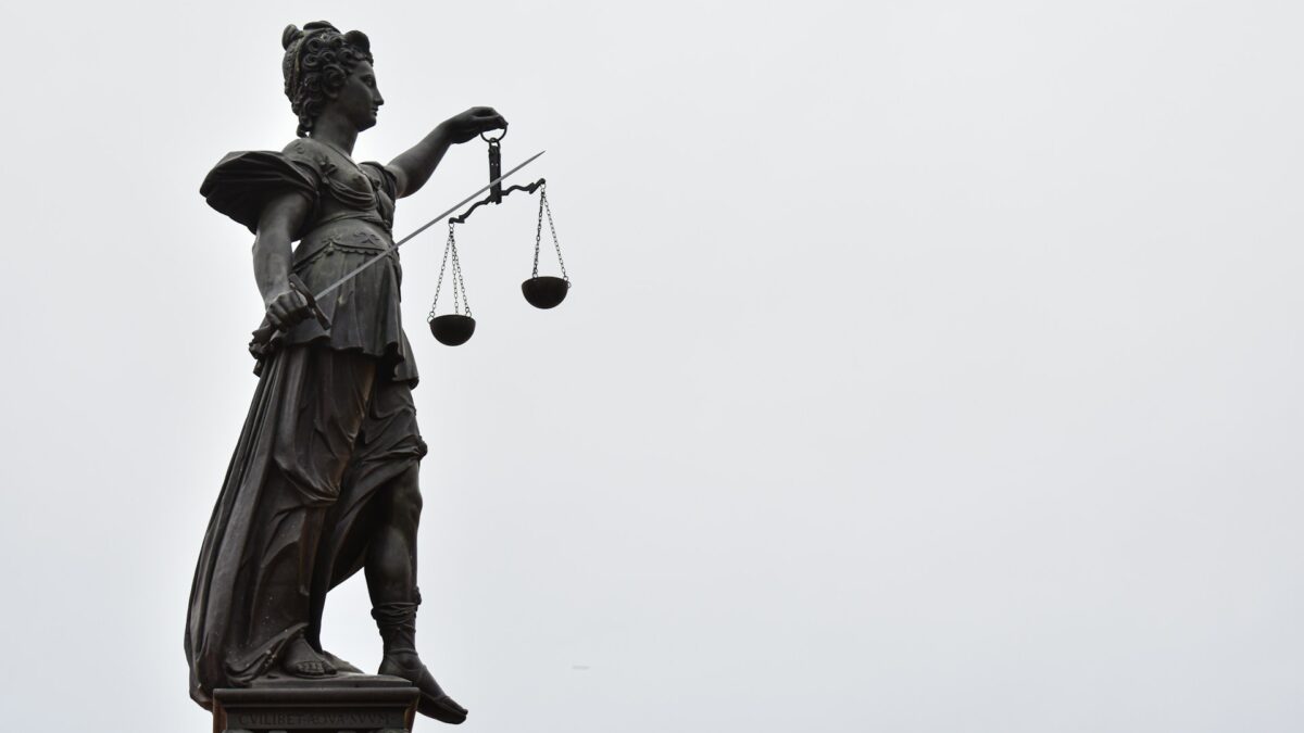 Justizia-Statue mit Waage und verbundenen Augen.