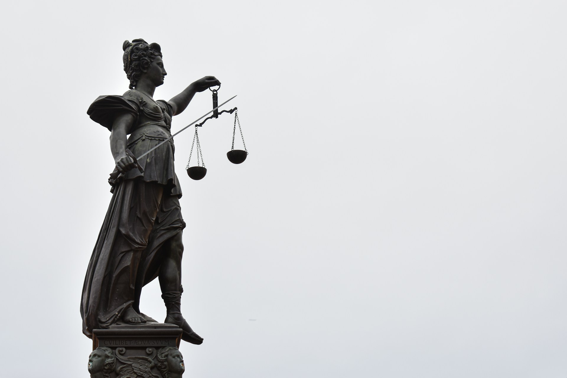 Justizia-Statue mit Waage und verbundenen Augen.