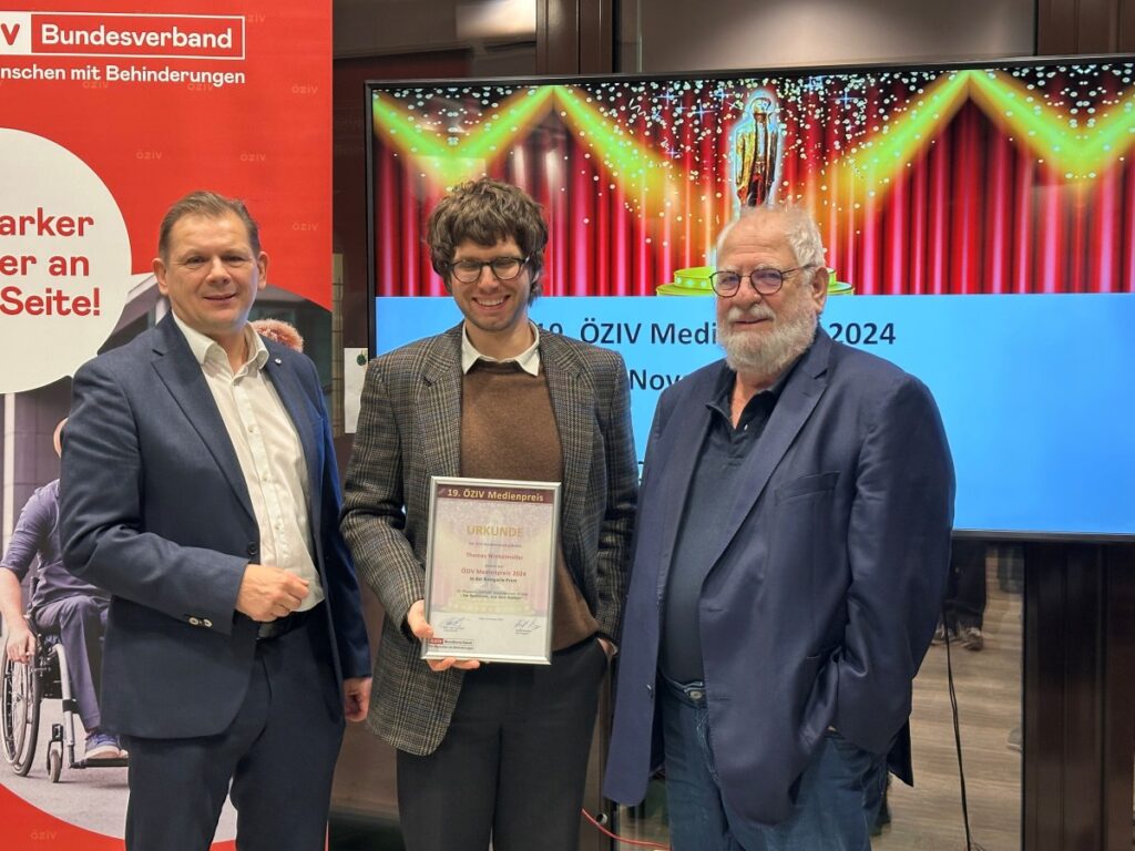 3 Männer stehen nebeneinander vor einem Rollup