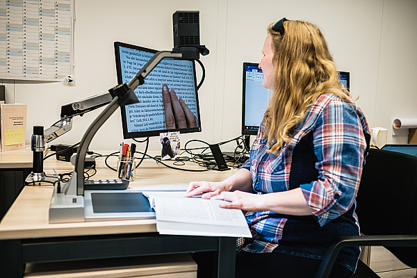 Frau mit Sehbehinderung arbeitet an einem mit Hilfsmitteln ausgestatteten Büroarbeitsplatz, (c) Andi Weiland | Gesellschaftsbilder.de