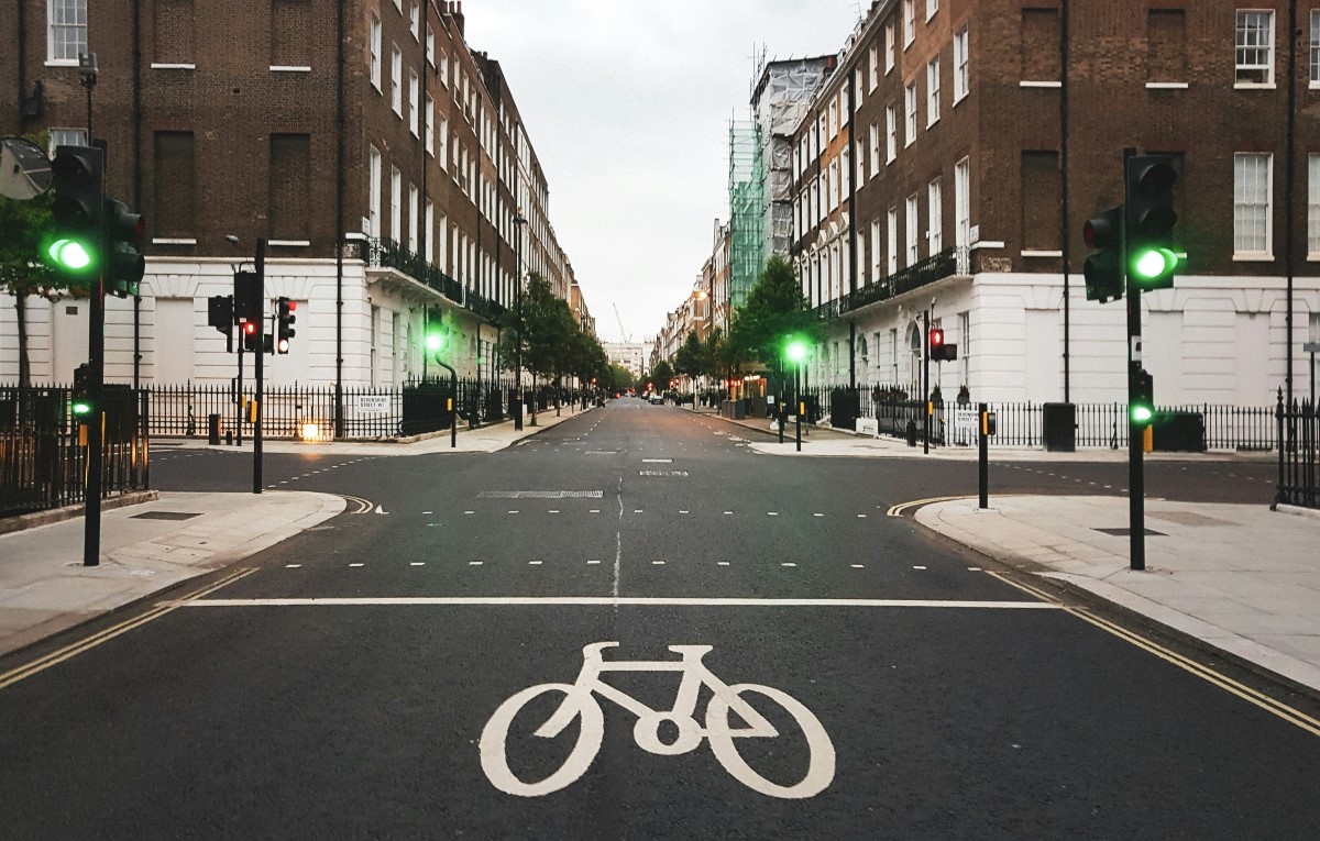 breite Straße mit Fahhradzone, davor eine ampelgeregelte Kreuzung, Foto: Unsplash/Dimitry B