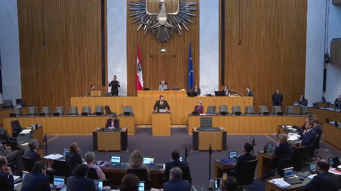 Bild eines Mannes, der im Nationalratssaals des Österreichischen Parlament eine Rede hält.