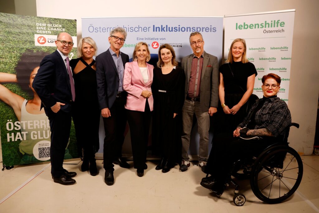 Gruppenfoto 8 festlch gekleideter, stehender Personen
