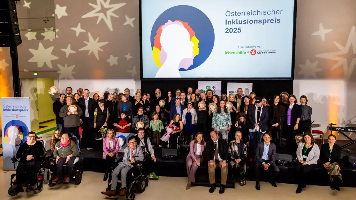 Gruppenfoto sitzender und stehender Personen auf einer Bühne