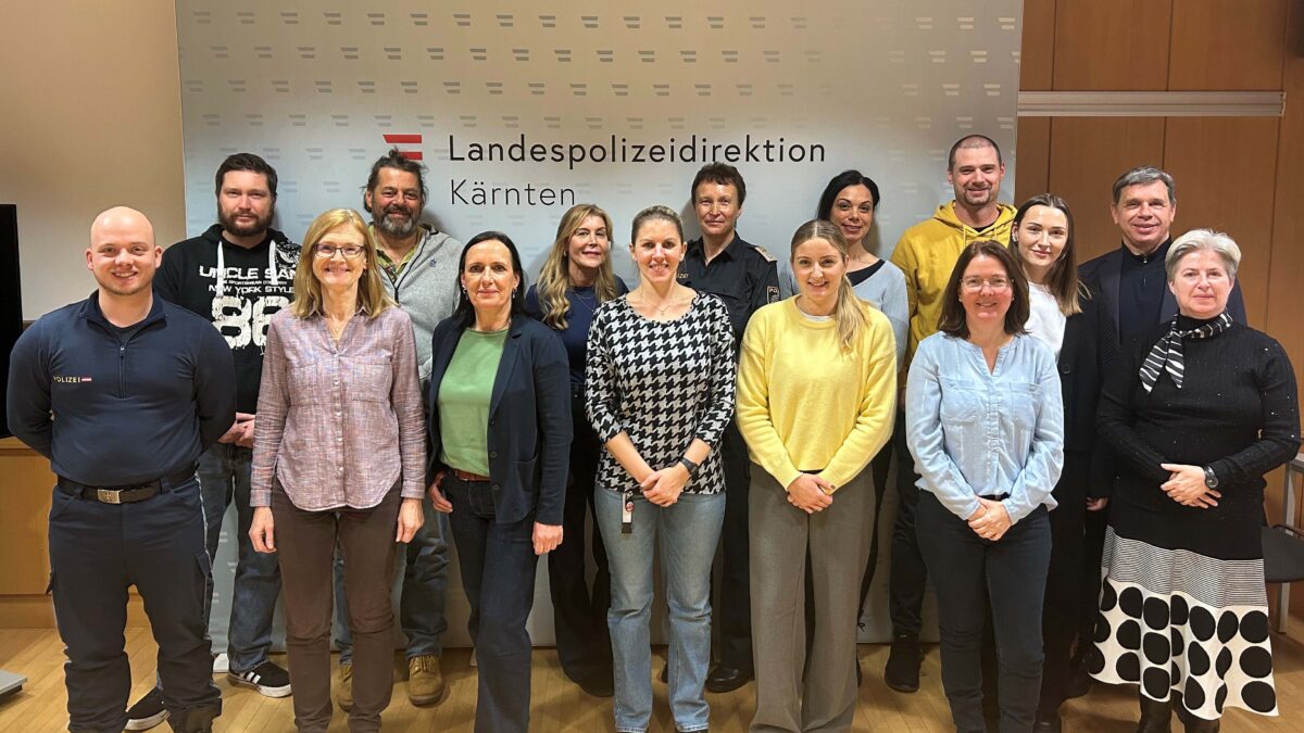 Gruppenbild stehender Personen in Zivilkleidung