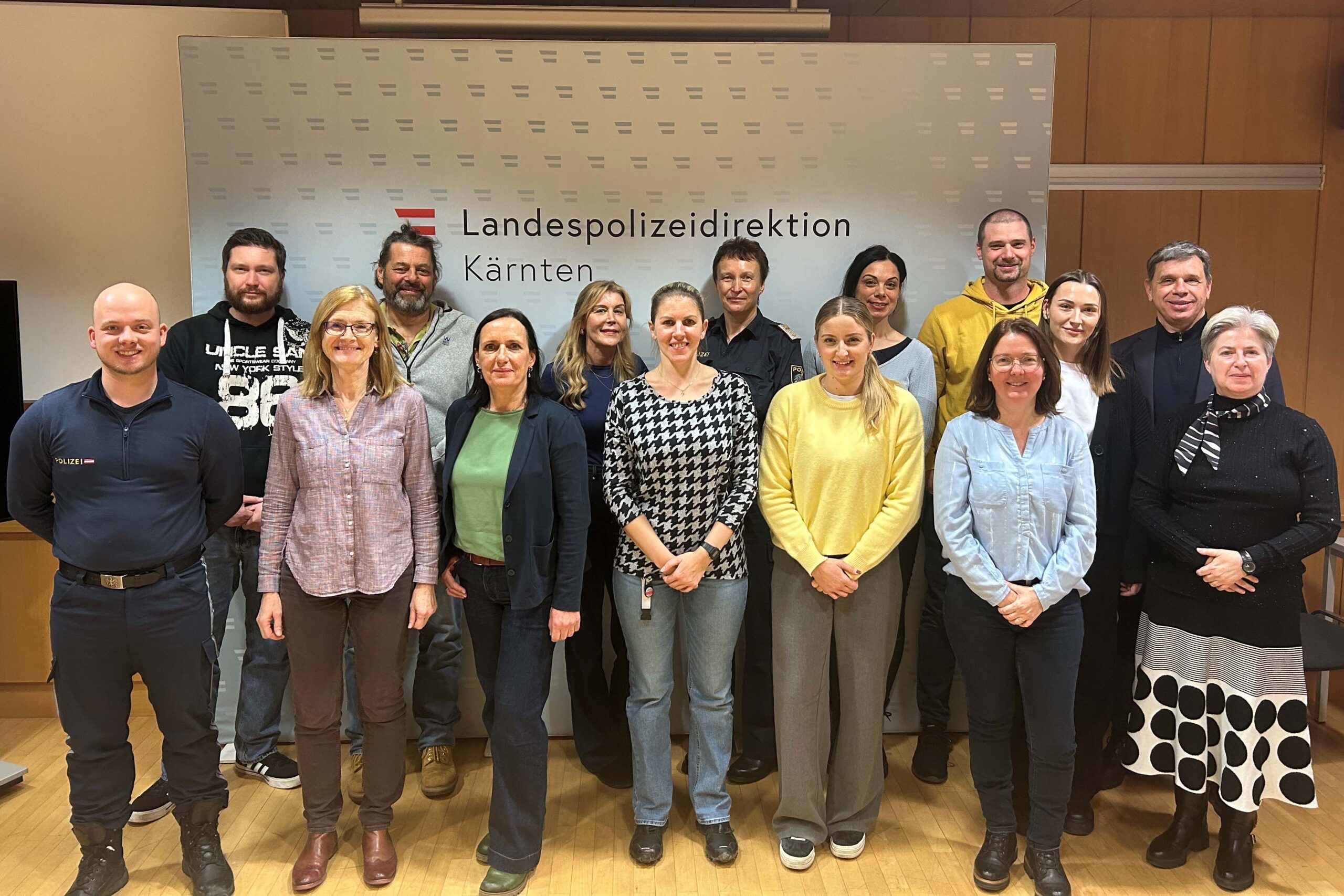 Gruppenbild stehender Personen in Zivilkleidung