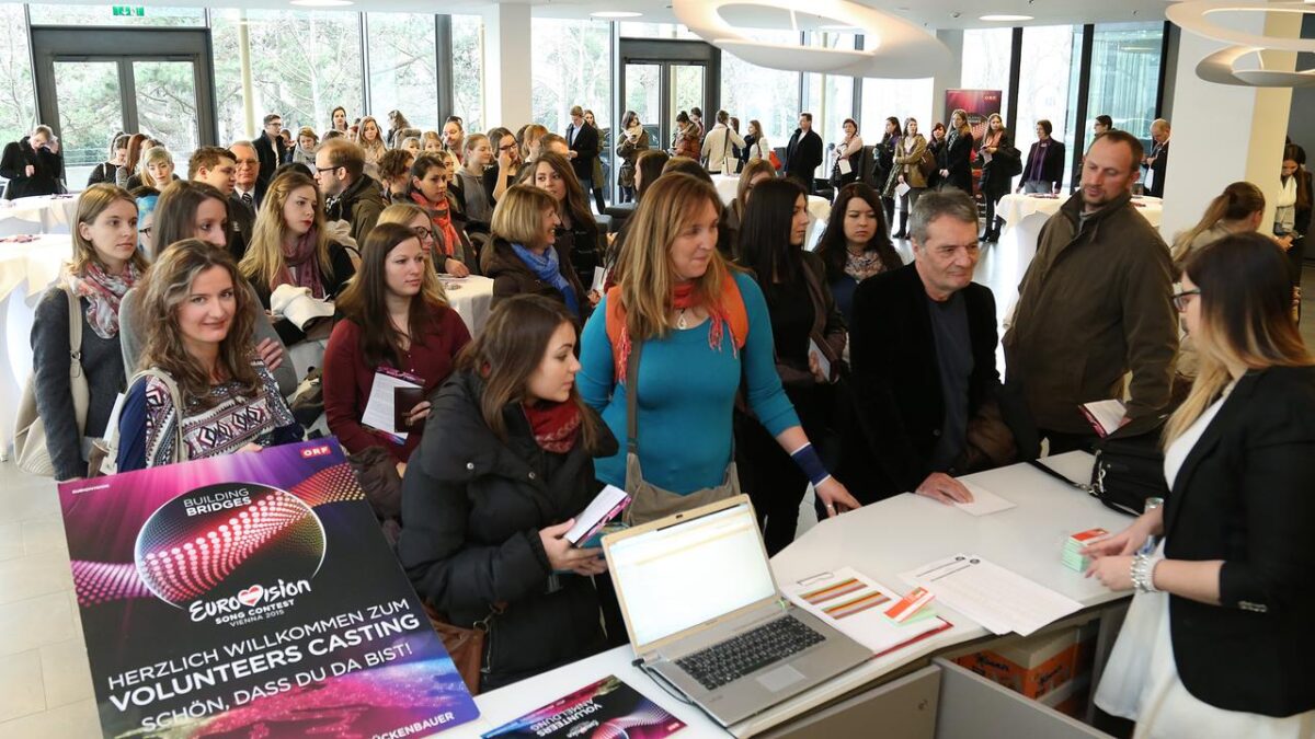 Menschen stehen vor einem Schalter und warten, bis sie an der Reihe sind
