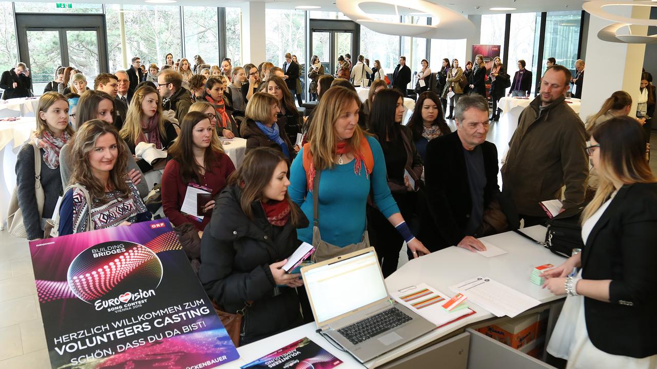 Menschen stehen vor einem Schalter und warten, bis sie an der Reihe sind