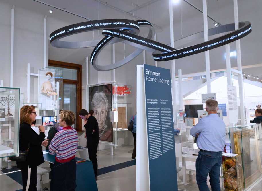 Besucherinnen und Besucher im Haus der Geschichte Österreich, über ihnen ragt eine Installation.