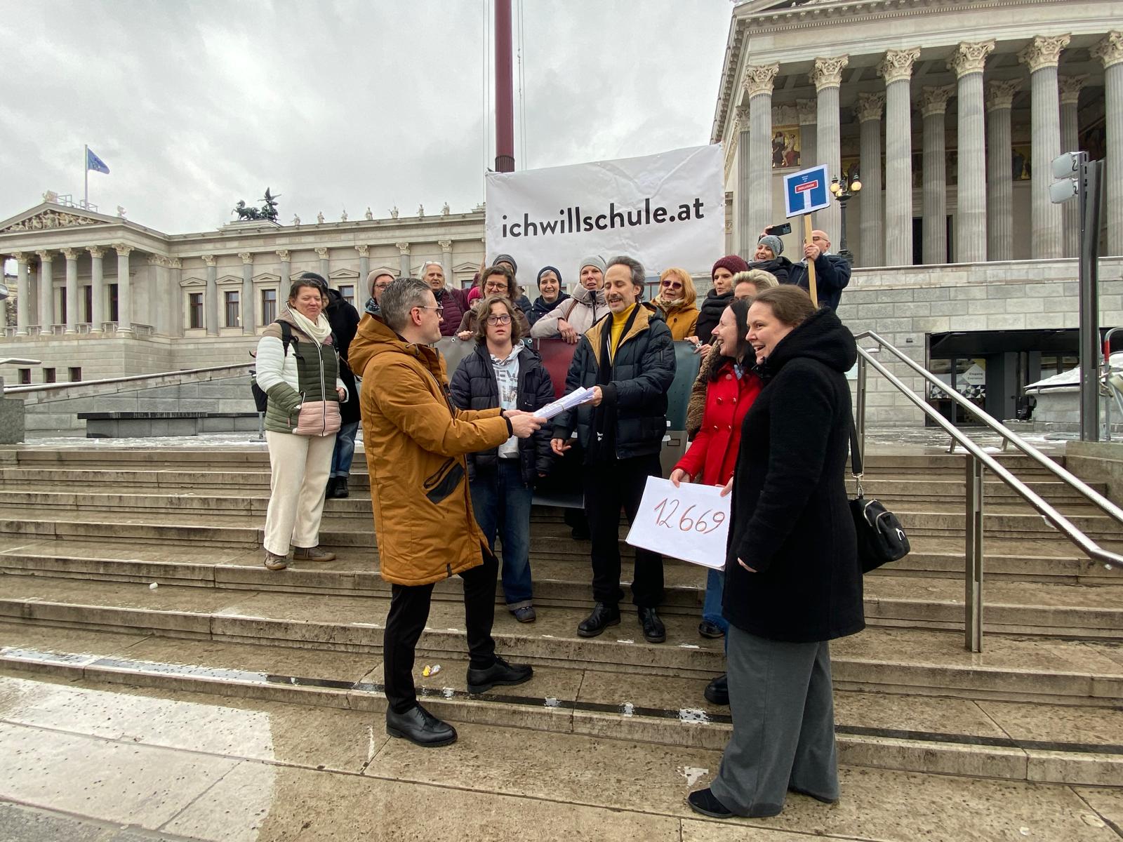 Menschengruppe steht auf der Treppe vor dem Parlament
