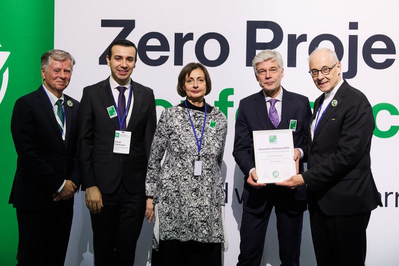 Gruppenbiold 5 stehender Personen, alle elegant gekleidet, im Hintergrund Banner "Zero Project"