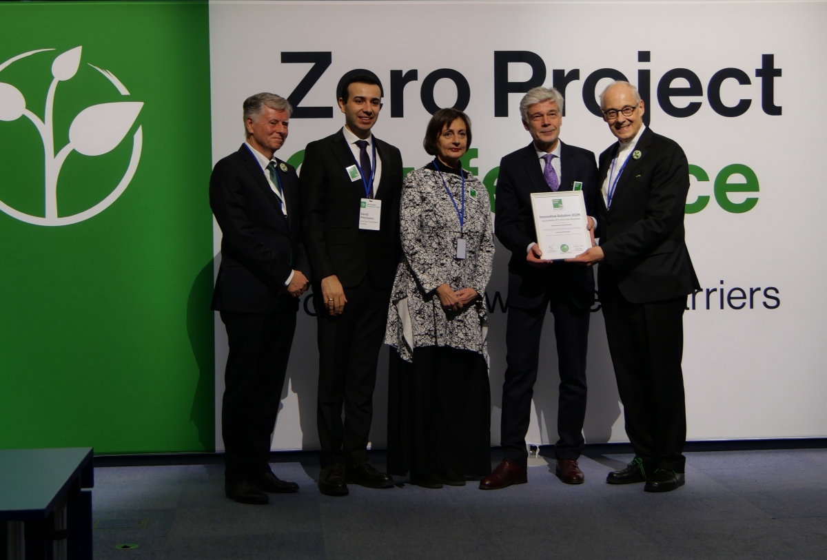 Gruppenbild 5 stehender Personen, alle elegant gekleidet, im Hintergrund Banner "Zero Project"
