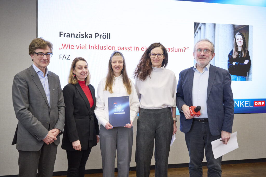 Franziska Pröll erhält den Herbert-Pichler-Inklusions-Medienpreis 2026 in der Kategorie Printmedien. Sie steht gemeinsam mit Gabriele Falböck, Fritz Hausjell, Martin Zach und Ines Stilling auf einer Bühne vor einer Präsentationsfolie mit Titel und Porträtbild.