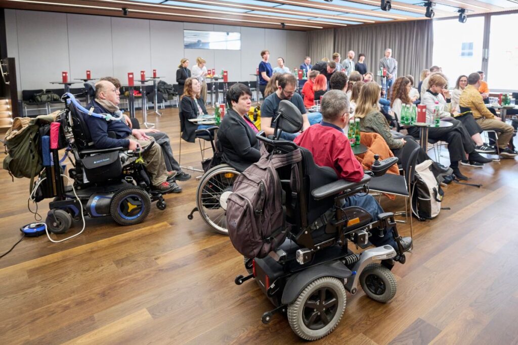 Mehrere Personen sitzen in einem Raum bei der Verleihung des Herbert Pichler-Inklusions-Medienpreises