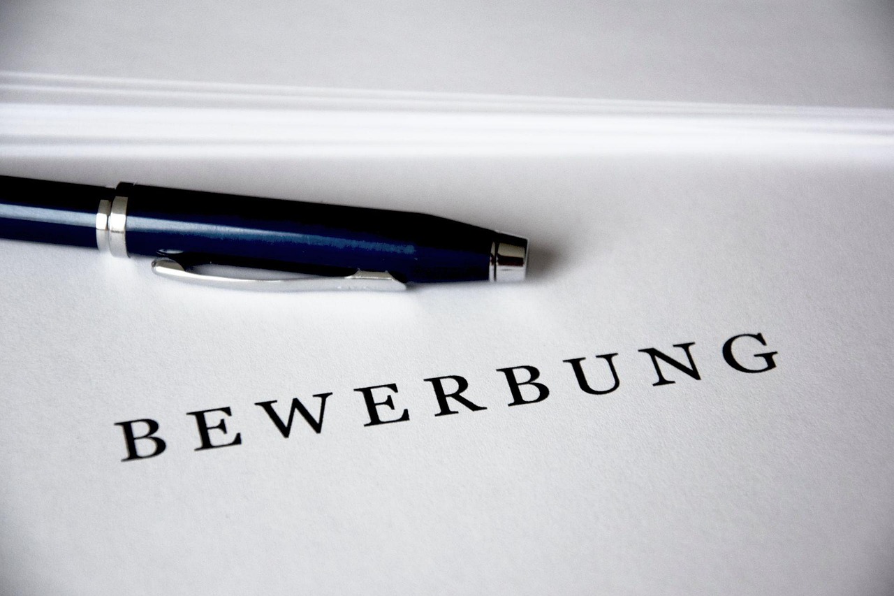 Papier mit der Aufschrift „Bewerbung“ und Kugelschreiber darauf.. Foto: Pixabay/loufre
