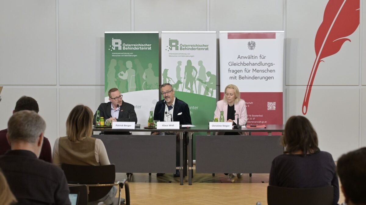 Patrick Berger, Klaus Widl und Christine Steger am Podium vor Roll-ups des Österreichischen Behindertenrats bei der Pressekonferenz zum Ausgleichstaxfonds.