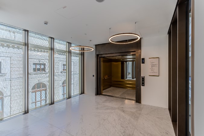 Offene Lifttüren eines großen Besucherlifts im Naturhistorischen Museum Wien. Der barrierefreie Lift befindet sich in einem hellen Vorraum mit großen Fenstern und bietet ausreichend Platz für Rollstuhlfahrer und mehrere Personen.