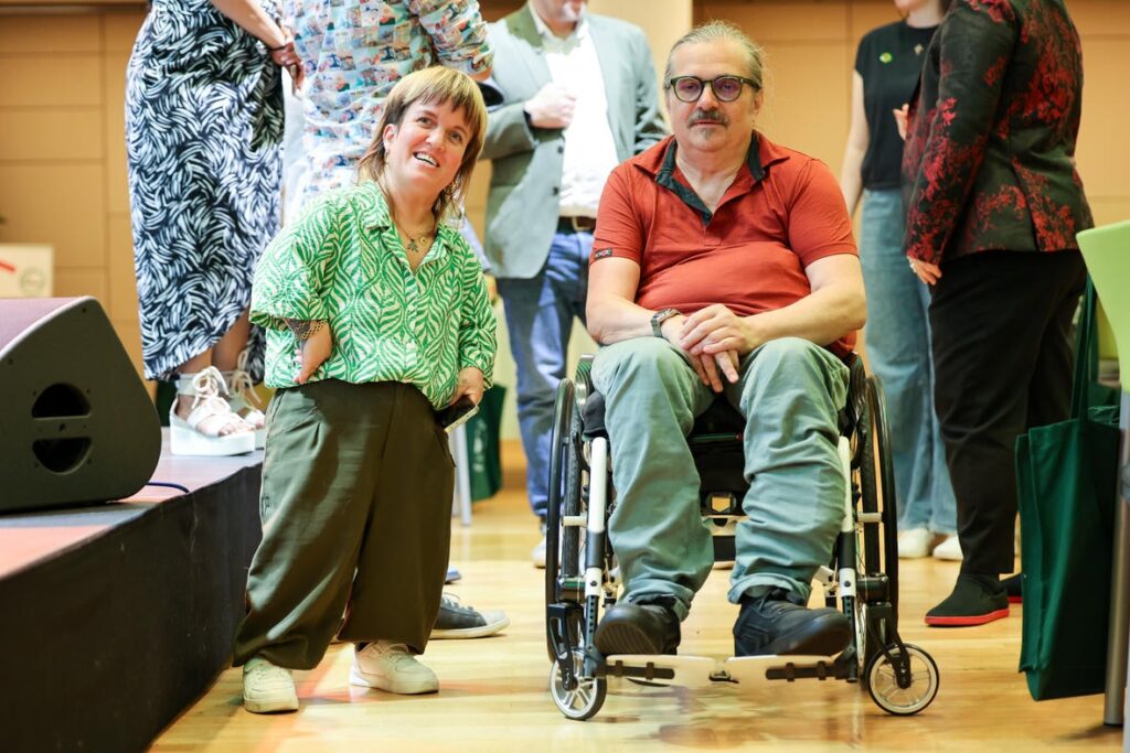 Daniela Rammel und ein Mann im Rollstuhl stehen bei der Jubiläumsfeier des Österreichischen Behindertenrats im Gespräch.