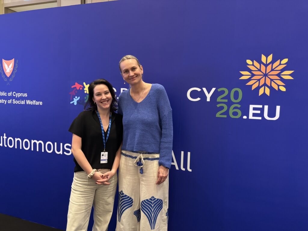 Victoria Biber und Helene Jarmer stehen vor einer blauen Veranstaltungswand der zypriotischen EU-Ratspräsidentschaft 2026.