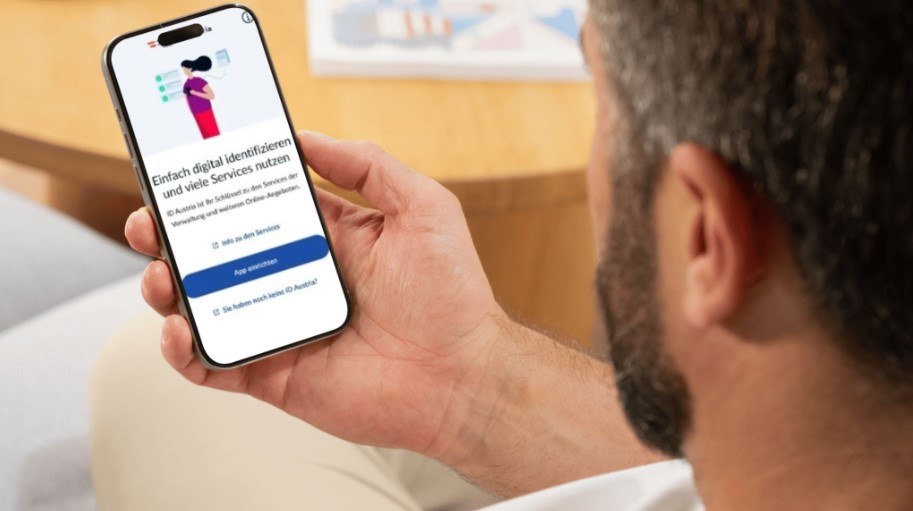 Smartphone mit geöffneter ID-Austria-App in einer Hand. Auf dem Bildschirm sind digitale Verwaltungsservices dargestellt. Symbolfoto für digitale Identität und Online-Amtswege in Österreich.