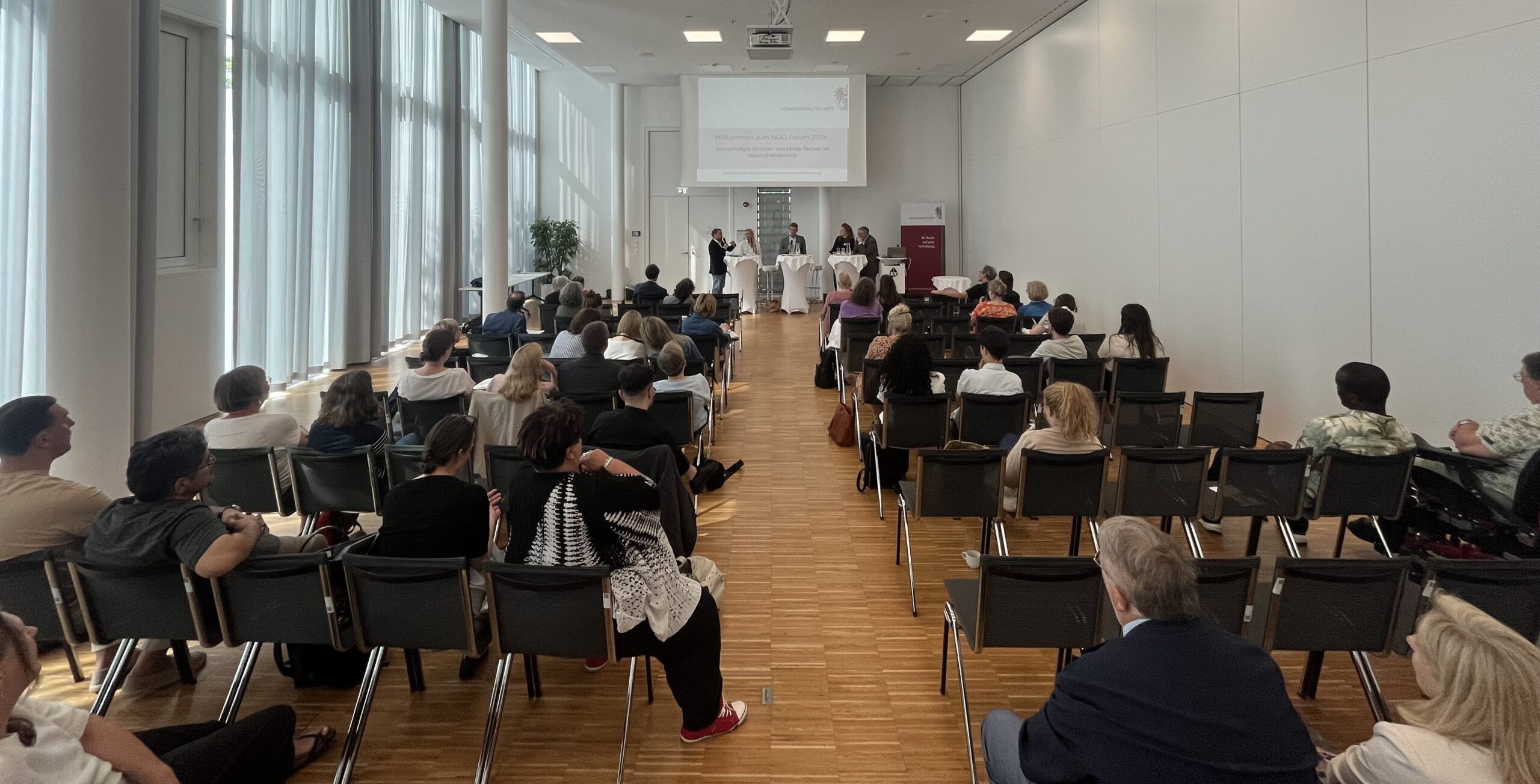 Sitzungssaal mit zahlreichen Personen von hinten fotografiert