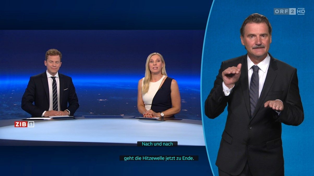 Screenshot der Zeit im Bild 1 auf ORF 2: Moderator und Moderatorin im ZIB-Studio, rechts ein Gebärdensprachdolmetscher in neuer, größerer Einblendung. Am unteren Bildrand sind Untertitel sichtbar.