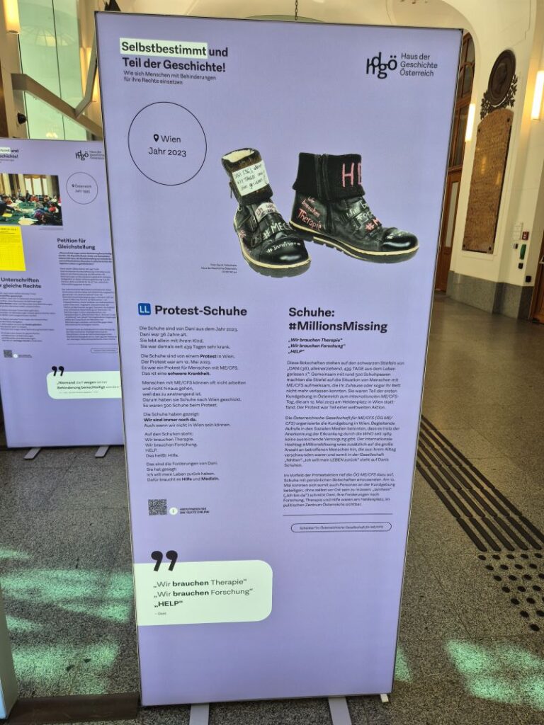 Lila Ausstellungstafel mit beschrifteten Protestschuhen der Aktion „#MillionsMissing“ sowie Informationen zu ME/CFS und einer Protestaktion im Jahr 2023.