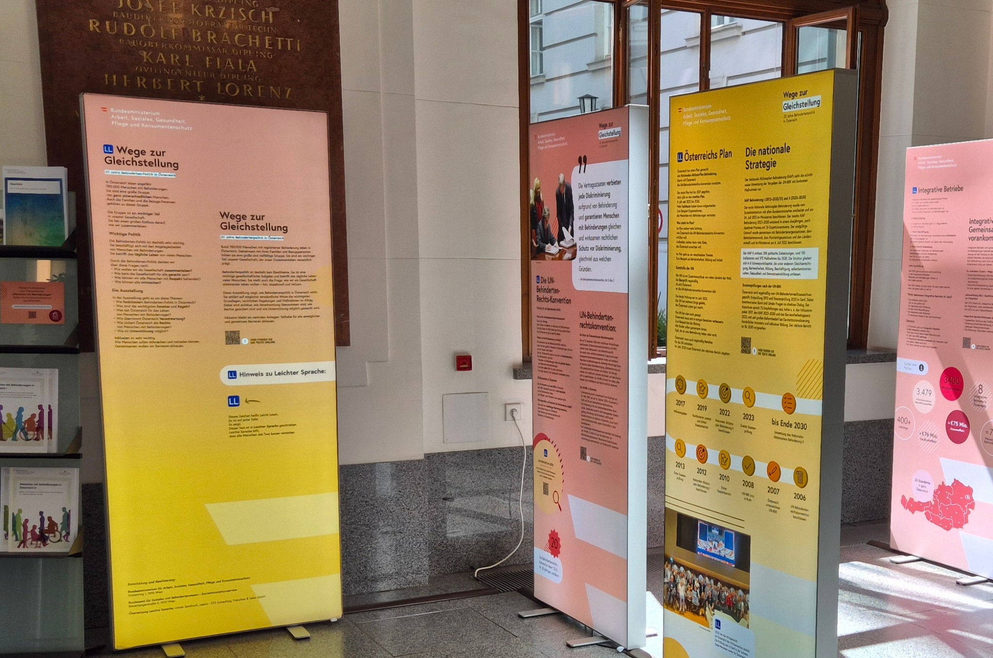 Mehrere Ausstellungstafeln der Ausstellung „Wege zur Gleichstellung“ stehen in der Eingangshalle des Sozialministeriums. Sie zeigen Informationen zur Behindertenpolitik und Gleichstellung in Österreich.