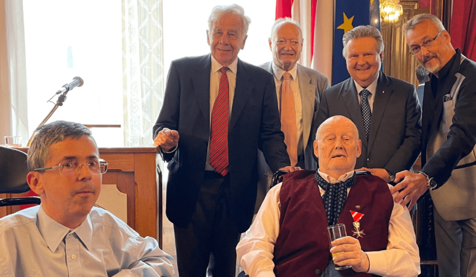 Mag. Franz Karl sitzt mit dem Silbernen Ehrenzeichen für Verdienste um die Republik Österreich im Rollstuhl. Hinter ihm stehen, von links nach rechts, Dr. Bernhard Görg, Dr. Andreas Khol, Bürgermeister Dr. Michael Ludwig und Klaus Widl. Links im Bild sitzt Martin Ladstätter.