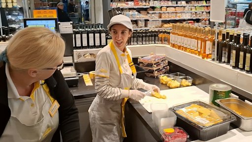Elif bei der Arbeit im BILLA PLUS Markt in Feldbach, gemeinsam mit einer Kollegin bei der Zubereitung von Lebensmitteln.