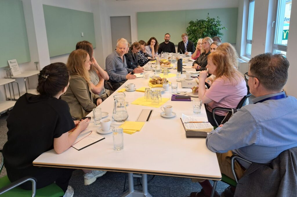 Vertreter*innen von ÖBÍ réttindasamtök und Österreichischem Behindertenrats sitzen rund um einen Besprechungstisch im Büro des Austrian Disability Council.