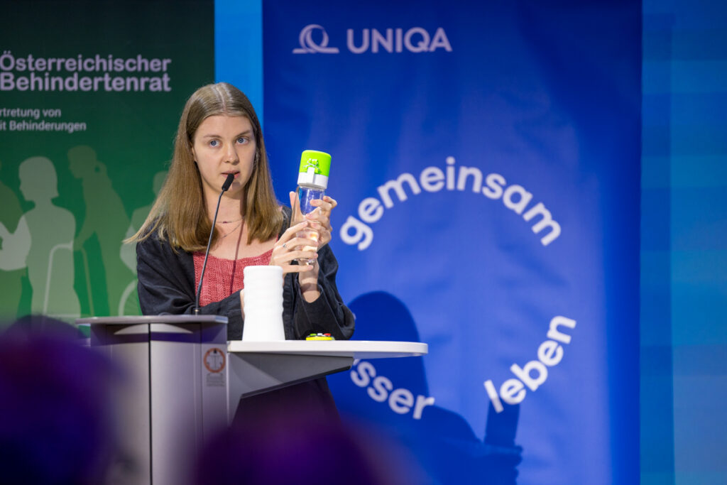 Frau präsentiert bei der Preisverleihung UNIKATE 2026 ihr Projekt "Trinkflasche"