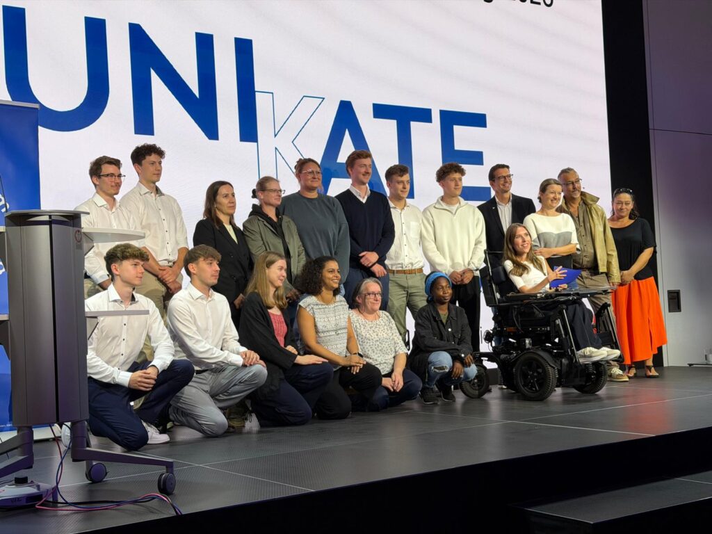 Preisträgerinnen und Preisträger der UNIKATE Preisverleihung 2026 gemeinsam auf der Bühne vor dem UNIKATE-Logo.