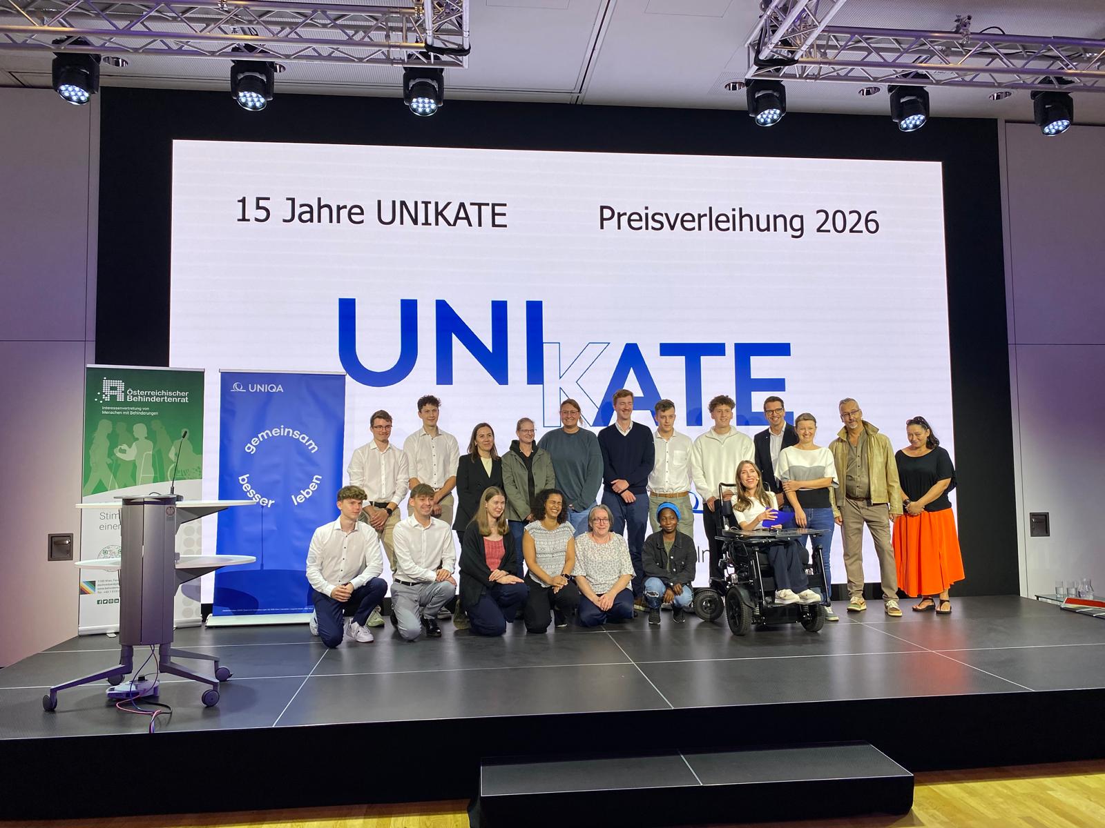 Preisträger*innen und Beteiligten der UNIKATE Preisverleihung 2026 gemeinsam auf der Bühne vor dem UNIKATE-Logo.