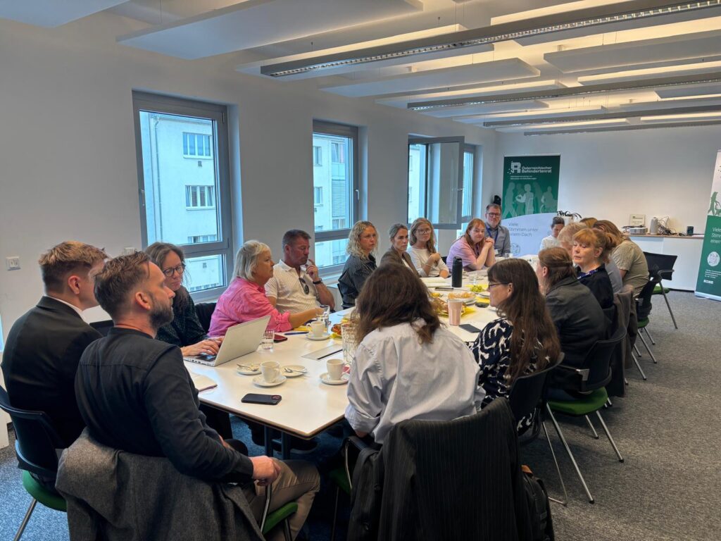 Vertreter*innen von ÖBÍ réttindasamtök und Österreichischem Behindertenrats sitzen rund um einen Besprechungstisch im Büro des Austrian Disability Council.