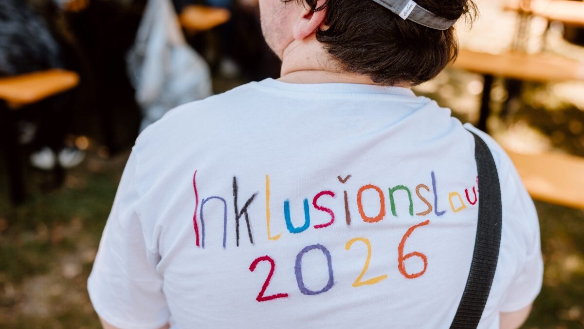 Teilnehmer*innen des 6. Grazer Inklusionslaufs mit T-Shirt, auf dem Inklusionslauf zu lesen ist