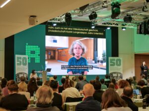Die Videobotschaft von Katrin Langensiepen wird im Saal gezeigt.