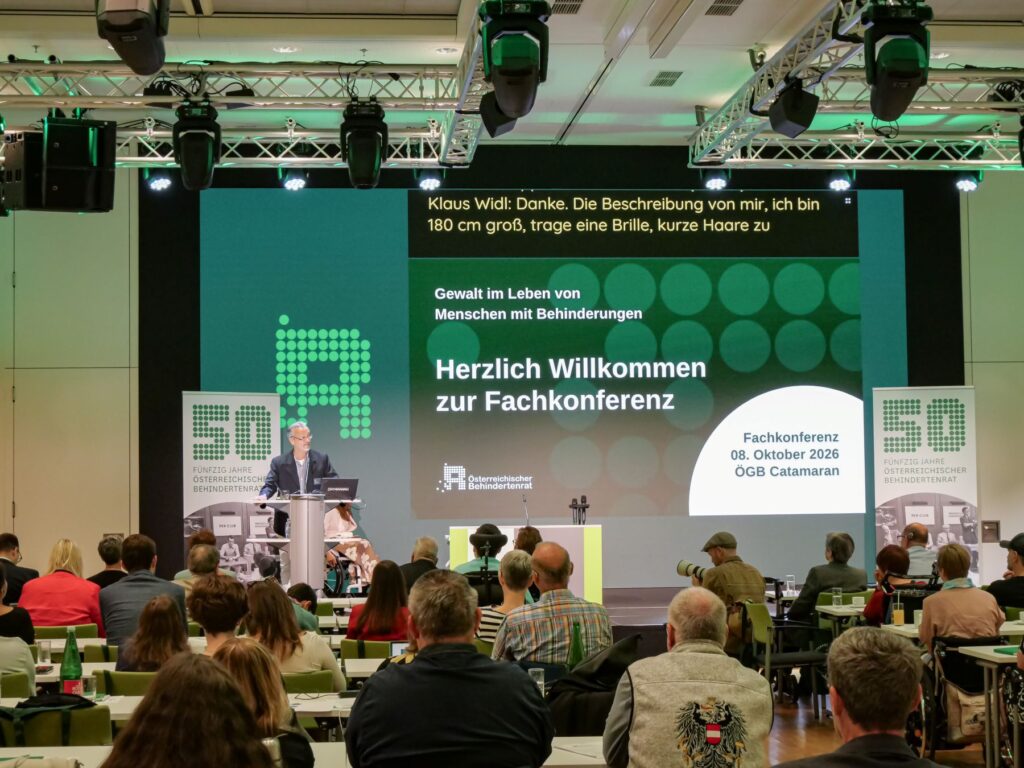 Klaus Widl, Präsident des Österreichischen Behindertenrats, hält die Begrüßungsworte bei der Fachkonferenz 2026 zum Thema „Gewalt im Leben von Menschen mit Behinderungen“. Im Vordergrund ist das Publikum zu sehen.